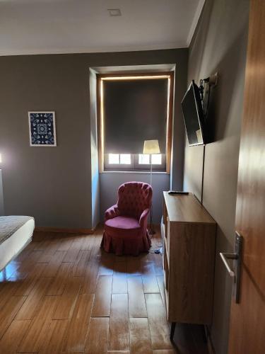 a room with a bed and a chair and a window at D'OURO DOM MANUEL By LW in Vila Nova de Gaia