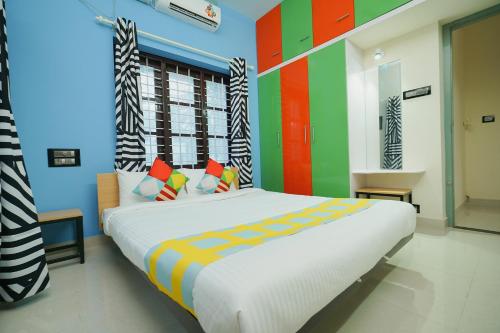 a bedroom with a large bed with colorful walls at Hotel O Majestic Stays in Kazhakuttam