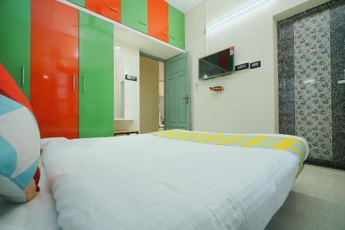 a bedroom with a white bed and colorful walls at Hotel O Majestic Stays in Kazhakuttam