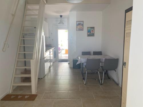 - un escalier dans une pièce avec une table et des chaises dans l'établissement Maisonnette climatisée à louer 5 nuits minimum dans résidence fermée proche mer, à Bandol