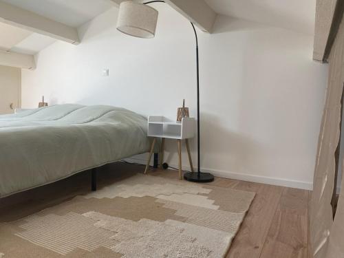 - une chambre avec un lit, une lampe et une table dans l'établissement Maisonnette climatisée à louer 5 nuits minimum dans résidence fermée proche mer, à Bandol