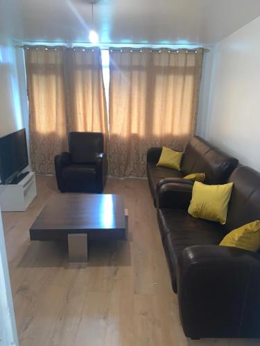 Una sala de estar con un sofá y una mesa de café. en Ellison House, en Londres