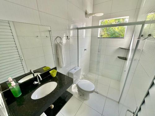 a bathroom with a sink and a toilet and a shower at Tatu Do Bem Hospedagem in Serra