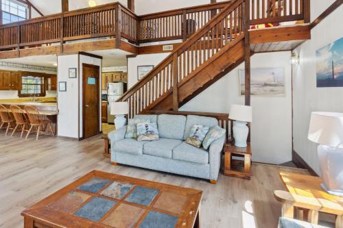 a living room with a blue couch and a staircase at 2029 - Duck Yeah in Duck