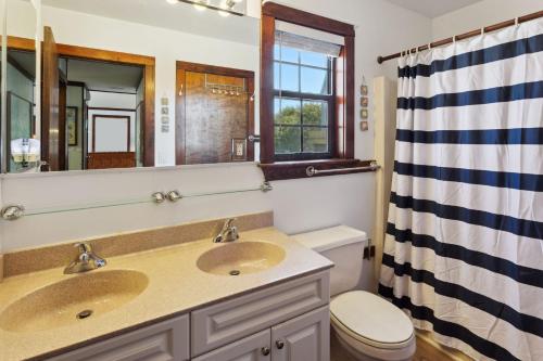 a bathroom with two sinks and a toilet and a mirror at 2029 - Duck Yeah in Duck