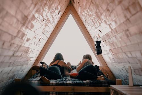 eine Gruppe von Mädchen sitzt auf einem Bett in einem Zimmer mit einem Fenster in der Unterkunft Grand Canyon A-Frame Hot-tub & Sauna in Williams