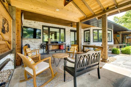 a patio with chairs and a table and some windows at Cotter Home with Direct Access to White River! in Cotter