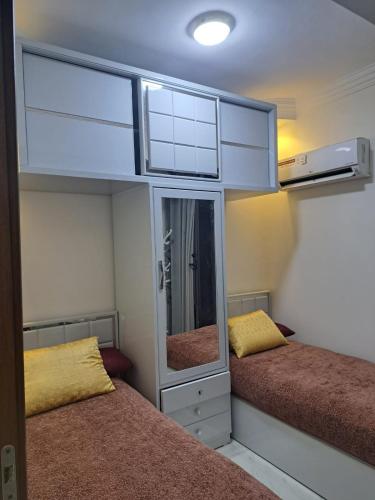 a small room with two beds and a mirror at Modern 2 Bedroom Apartment Prime Location with Stylish Interiors in Cairo