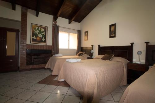 a room with two beds and a fireplace at Comfort Hostel in Guatemala