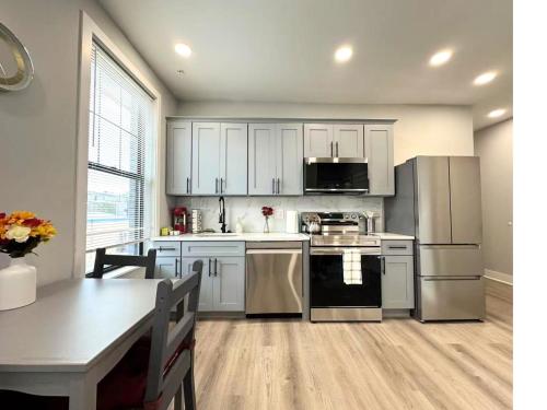 a kitchen with white cabinets and stainless steel appliances at New 1BR Walk to Pats & Genos in Philadelphia