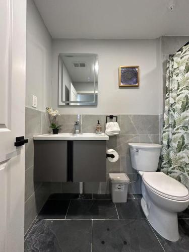 a bathroom with a sink and a toilet and a mirror at New 1BR Walk to Pats & Genos in Philadelphia