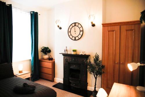 a living room with a clock on the wall at The Eastbourne Suite, FREE CAR PARK in Eastbourne