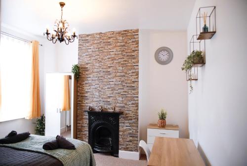 a bedroom with a brick fireplace and a bed at The Eastbourne Suite, FREE CAR PARK in Eastbourne