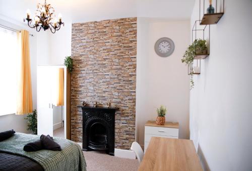 a bedroom with a brick fireplace and a table at The Eastbourne Suite, FREE CAR PARK in Eastbourne