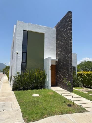 a white house with a large glass door at Casa de Campo Lake Shore Jocotepec in San Cristóbal Zapotitlán