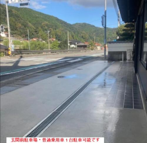 an empty street with water on the ground at 福のや in Unnan