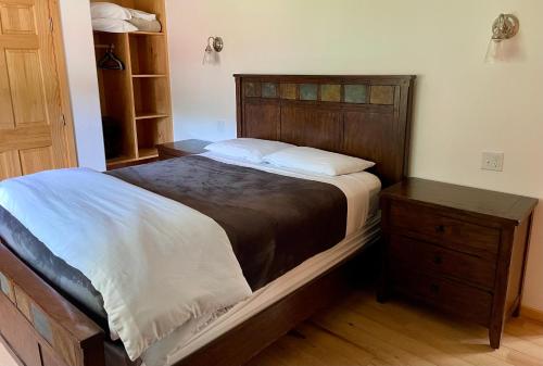 a bedroom with a large bed and a wooden dresser at Talkeetna Wilderness Lodge & Cabin Rentals in Sunshine