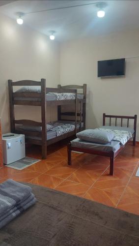 a room with two bunk beds and a tv at Mãe Maria in Aparecida