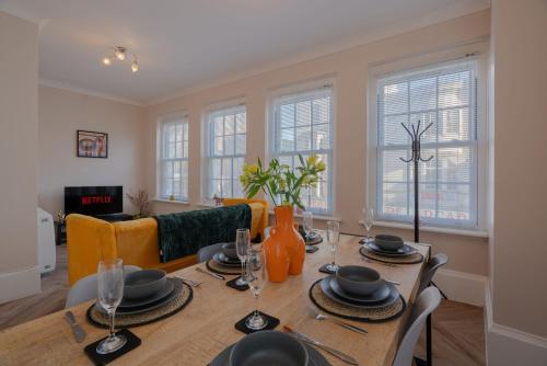 a dining room with a table and chairs and windows at Central Brighton, 2 bedrooms, sleeps 5 in Brighton & Hove