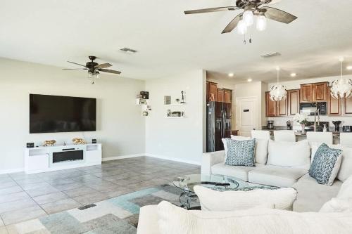 a living room with a white couch and a tv at GoldStar Luxury Home in Ruskin
