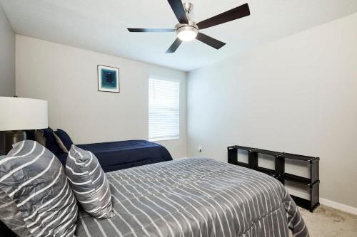 a bedroom with a bed and a ceiling fan at GoldStar Luxury Home in Ruskin