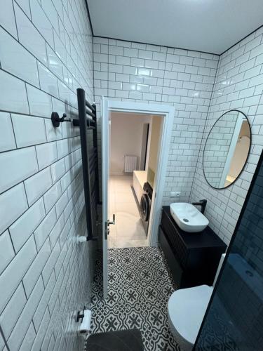 a bathroom with a toilet and a sink and a mirror at Kobuleti One in K'obulet'i