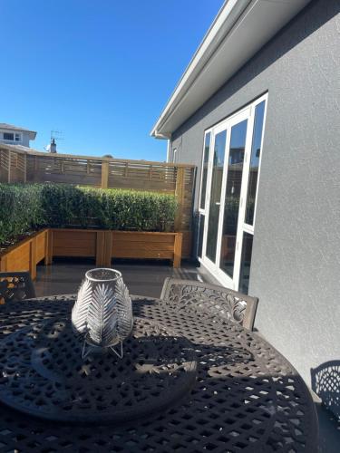 a patio with a table and chairs on a balcony at Gold Star Haven in Napier