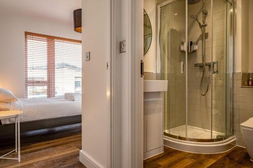 a bathroom with a shower and a bed at Beach Haven in Perranporth