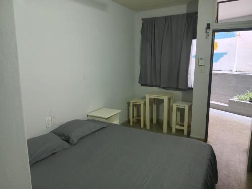 a bedroom with a bed and two tables and a window at Hotel embajador in Clorinda