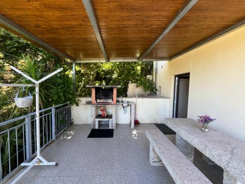 a porch with two benches and a wooden ceiling at Casa de Casarelhos - "Gerês" - Estúdio piso 0 - Apartamento Piso 1 in Geres