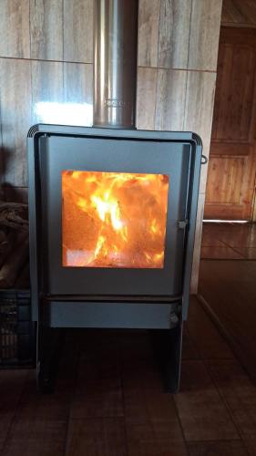 una estufa con fuego en su interior en Cabañas Don Agustín Pucón, en Pucón