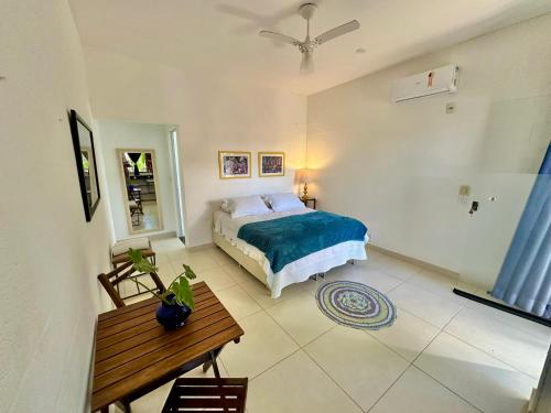 a bedroom with a bed and a table at Tatu Do Bem Hospedagem in Serra