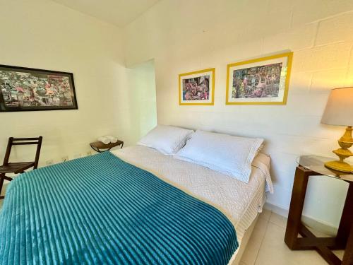 a bedroom with a bed with a blue blanket at Tatu Do Bem Hospedagem in Serra