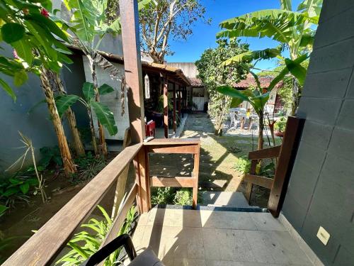 a wooden walkway leading to a building with a person sitting on the porch at Tatu Do Bem Hospedagem in Serra
