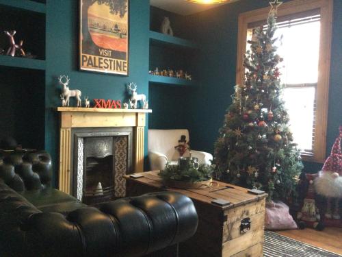 a living room with a christmas tree and a couch at Stunning Beach house in Gorleston-on-Sea