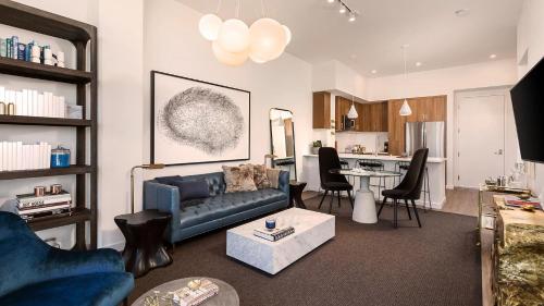 a living room with a blue couch and a kitchen at Luxury 1bedroom 1bath w Deck Gaslamp Quarter in San Diego