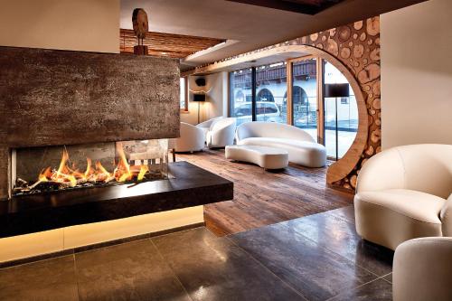 フィスにあるHotel Garni Montesの白い家具付きのリビングルームに暖炉があります。