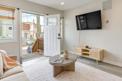 a living room with a couch and a tv on a wall at Walkable Baltimore Rowhouse with Fenced-In Patio! in Baltimore