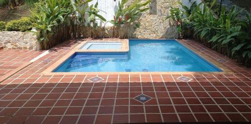 a small swimming pool on a brick walkway with a tile floor at La Gloria Ranch 