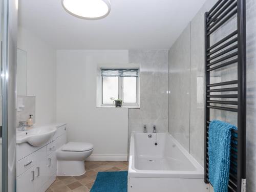 a bathroom with a tub and a toilet and a sink at Aunty Junes Cottage in Okehampton