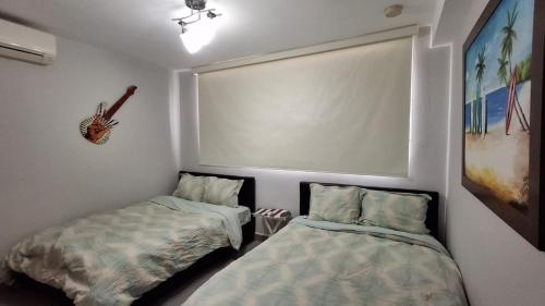 a bedroom with two beds and a picture on the wall at PH Las Islas Punta Barco Viejo a 3 min de Coronado in San José