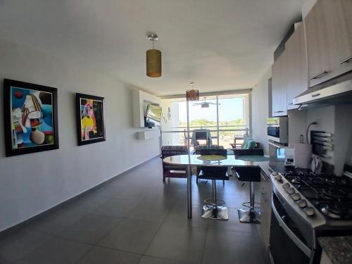 a kitchen with a table and a stove top oven at PH Las Islas Punta Barco Viejo a 3 min de Coronado in San José