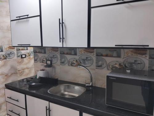 une cuisine avec un évier et un micro-ondes dans l'établissement شقق الفندقية ميامي امام بئر مسعود, à Alexandrie
