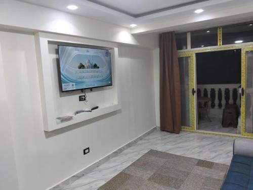 un salon avec une télévision à écran plat sur un mur dans l'établissement شقق الفندقية ميامي امام بئر مسعود, à Alexandrie