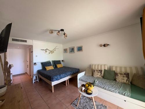 a living room with a couch and a bed at TI KAZ DOUDOU - village de vacances bord de mer in Sainte-Anne