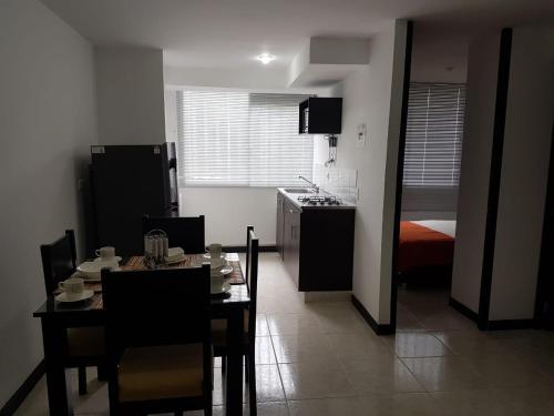 a kitchen and dining room with a table and a kitchen with a stove at Apartamentos para Turismo cerca a Parques Tematicos in Montenegro