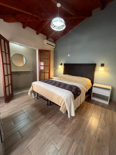a bedroom with a large bed and a wooden floor at Host Patagonia - DPX in Plaza Huincul