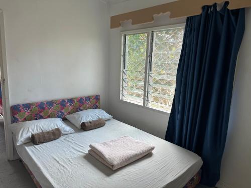 a bed in a room with a window at ND Good room in Nadi