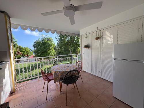 a kitchen with a table and chairs on a balcony at TI KAZ DOUDOU - village de vacances bord de mer in Sainte-Anne