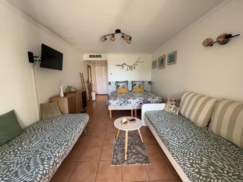 a living room with a couch and a table at TI KAZ DOUDOU - village de vacances bord de mer in Sainte-Anne